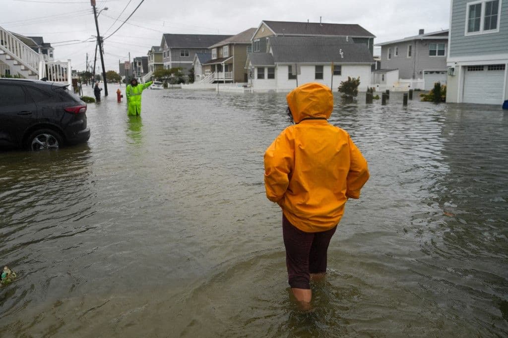 Varias personas caminan entre el agua en una carretera inundada durante la tormenta Nor'Easter, en una comunidad donde se ha emitido una orden de evacuación voluntaria el 26 de septiembre de 2026 en Point Pleasant, Nueva Jersey.