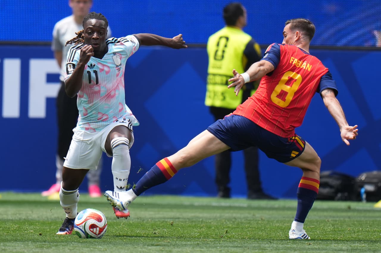 Fabián Ruiz busca quitarle el balón a Jeremy Doku.