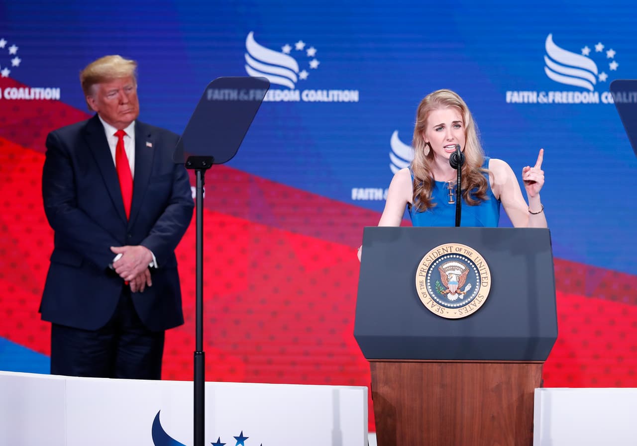 El presidente Donald Trump, a la izquierda, escucha a Natalie Harp, a la derecha, tras invitarla al escenario en la conferencia de la Coalición Fe y Libertad en Washington