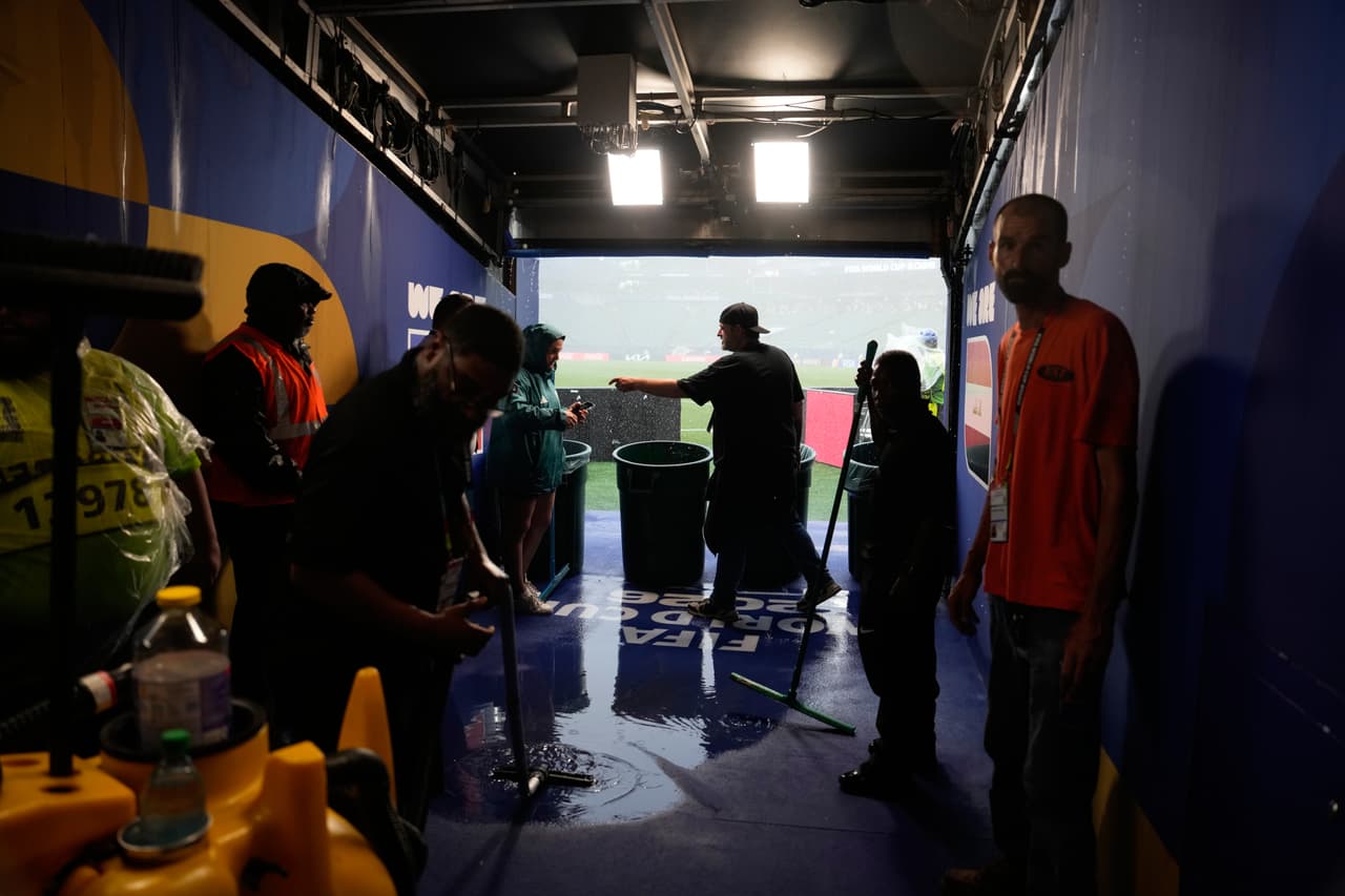 Trabajadores del campo de juego se reúnen en una zona protegida del estadio durante una alerta de tormenta eléctrica, en el partido de fútbol del Grupo I de la Copa del Mundo entre Francia e Irak, en Filadelfia, el lunes 22 de junio de 2026.