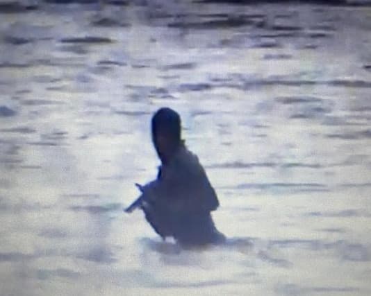 Imagen de un narcotraficante armado que cruzaba hacia México por el Río Grande, capturada en junio de 2021.