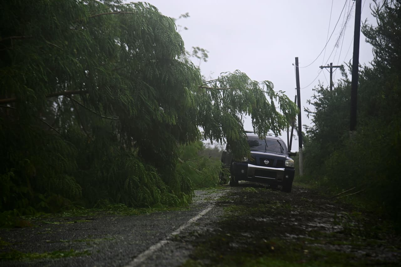 Un vehículo circula por una carretera en Salinas, Puerto Rico tras el paso de la tormenta tropical Laura.