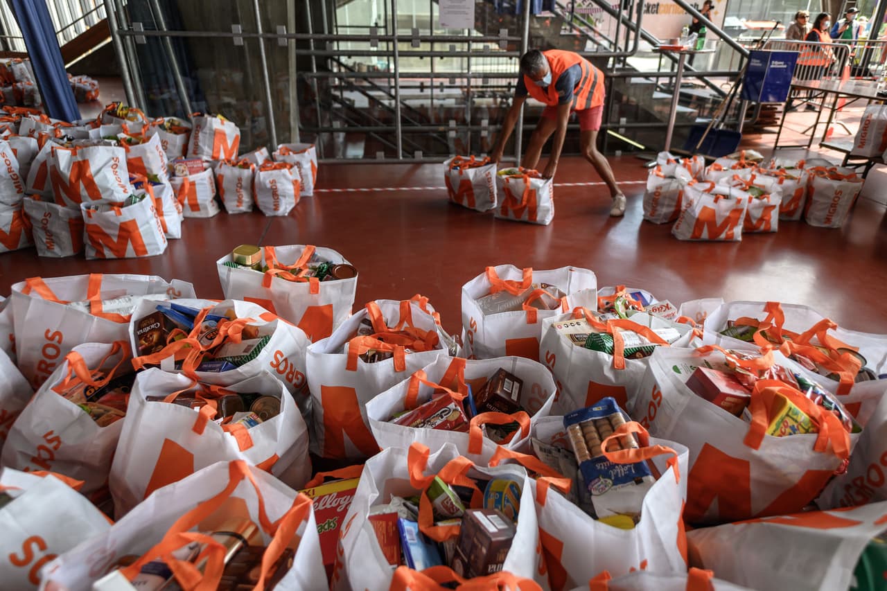 Un voluntario organiza las bolsas con alimentos para repartir a personas necesitadas en Ginebra, Suiza.