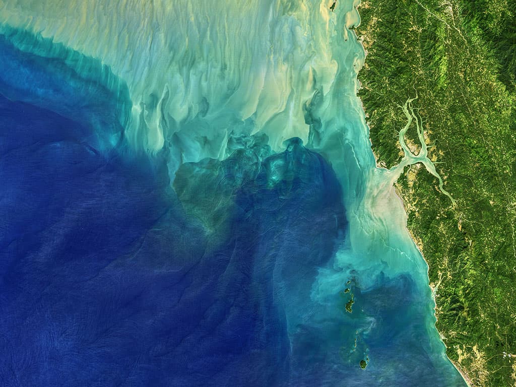 <b>Haciendo olas en el mar de Andamán.</b> Foto del 29 de noviembre de 2019. En el centro de la foto, donde las aguas turquesas y azules se unen, se ve un fenómeno de ondas internas en el océano. Esto se forma porque el océano está en capas: el agua profunda tiende a ser más fría, más densa y más salada, mientras que el agua menos profunda suele ser más cálida, más ligera y más fresca. Cuando las mareas, las corrientes, la gravedad y la rotación de la Tierra mueven estas diferentes masas de agua sobre las formaciones del fondo marino (como crestas o cañones), crean olas dentro del mar.
<br>
<br>
<br>
<br>