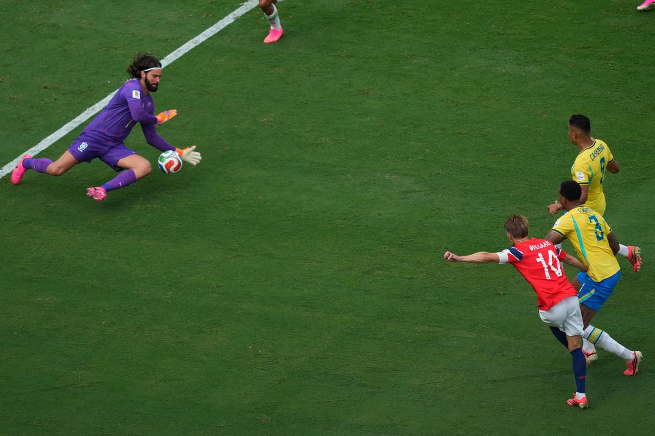 Alisson Becker ataja un disparo a Martin Oedegaard.