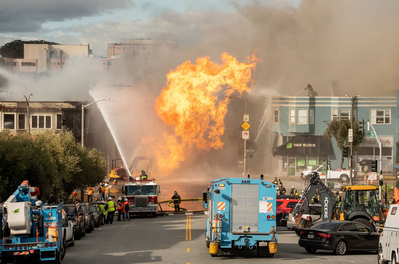 Los bomberos trabajan en la escena mientras las llamas se disparan al aire en una intersección en San Francisco, California, el 6 de febrero de 2019. - Una explosión en una tubería de gas en el distrito de Richmond envió llamas y humo a través de varios edificios mientras los equipos luchaban por controlar la situación. La jefa de bomberos de San Francisco, Joanne Hayes-White, informó que no hubo heridos. (Foto de Josh Edelson / AFP) (Foto de JOSH EDELSON/AFP a través de Getty Images)