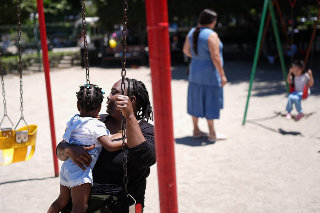 Vivianne Petit Frere sostiene a su nieta Alexca mientras se balancea con ella en un parque infantil, el 22 de junio de 2026, en Tijuana, México.
