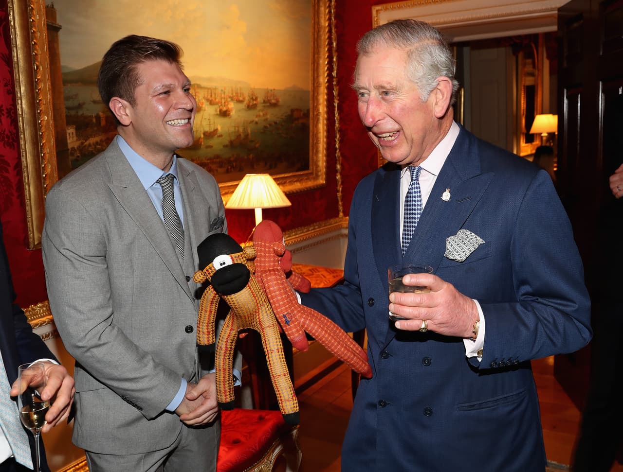 Ryan Palmer le obsequia al Príncipe de Gales dos monos hechos con calcentines, regalos para el Príncipe George y la Princesa Charlotte durante la reunión navideña, 'Style for Soldiers' celebrada en la Casa Spencer.