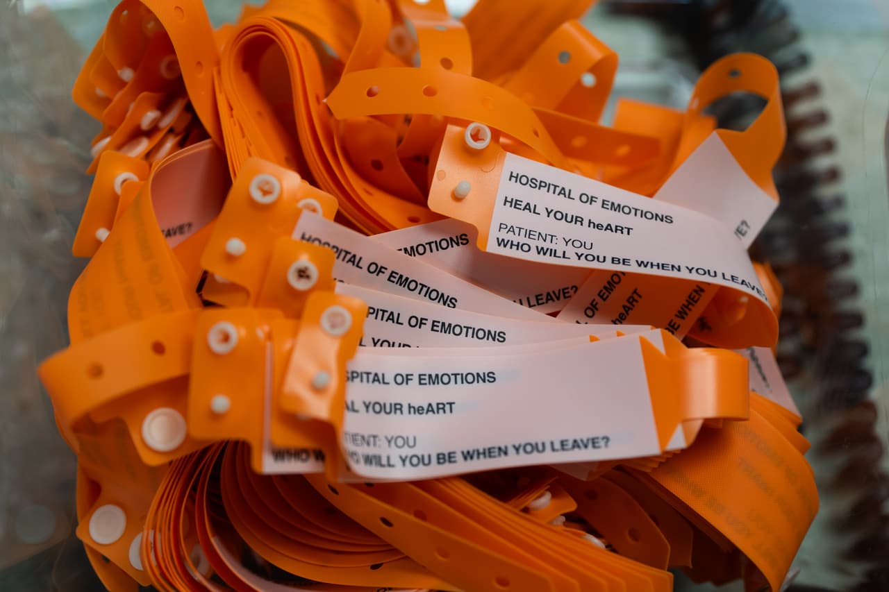 Pulseras de color naranja neón para pacientes y visitantes durante la exposición "Hospital de las Emociones" en un antiguo edificio hospitalario de Los Ángeles, el miércoles 22 de julio de 2026. (Foto AP/Jae C. Hong)