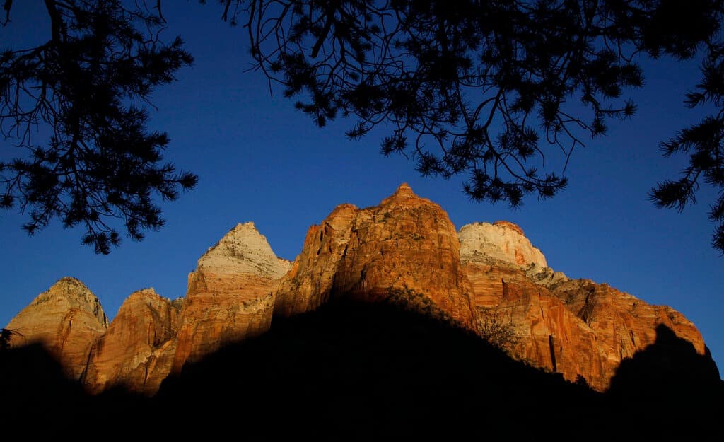 La luna se eleva sobre un acantilado de arenisca en el Parque Nacional Zion, el miércoles 1 de octubre de 2025, cerca de Springdale, Utah.