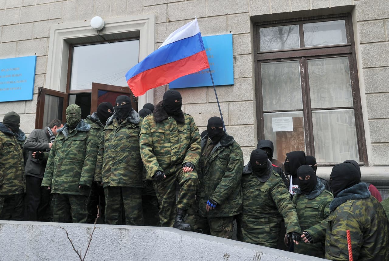 Individuos enmascarados no identificados alzan la bandera rusa y bloquean el edificio de Comercio de Simferopol, el centro administrativo de Crimea, el 1ro de marzo de 2014.