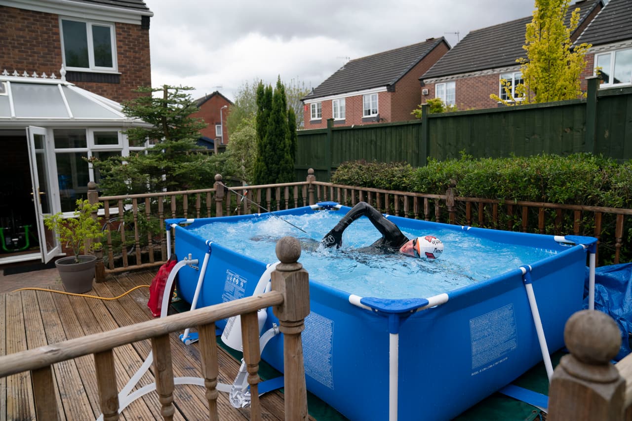 Amarrado para para aumentar el esfuerzo, el triatleta británico Lloyd Bebbington entrena en una piscina plástica en el jardín de su casa en Newcastle, Reino Unido. 30 de abril.
<br>