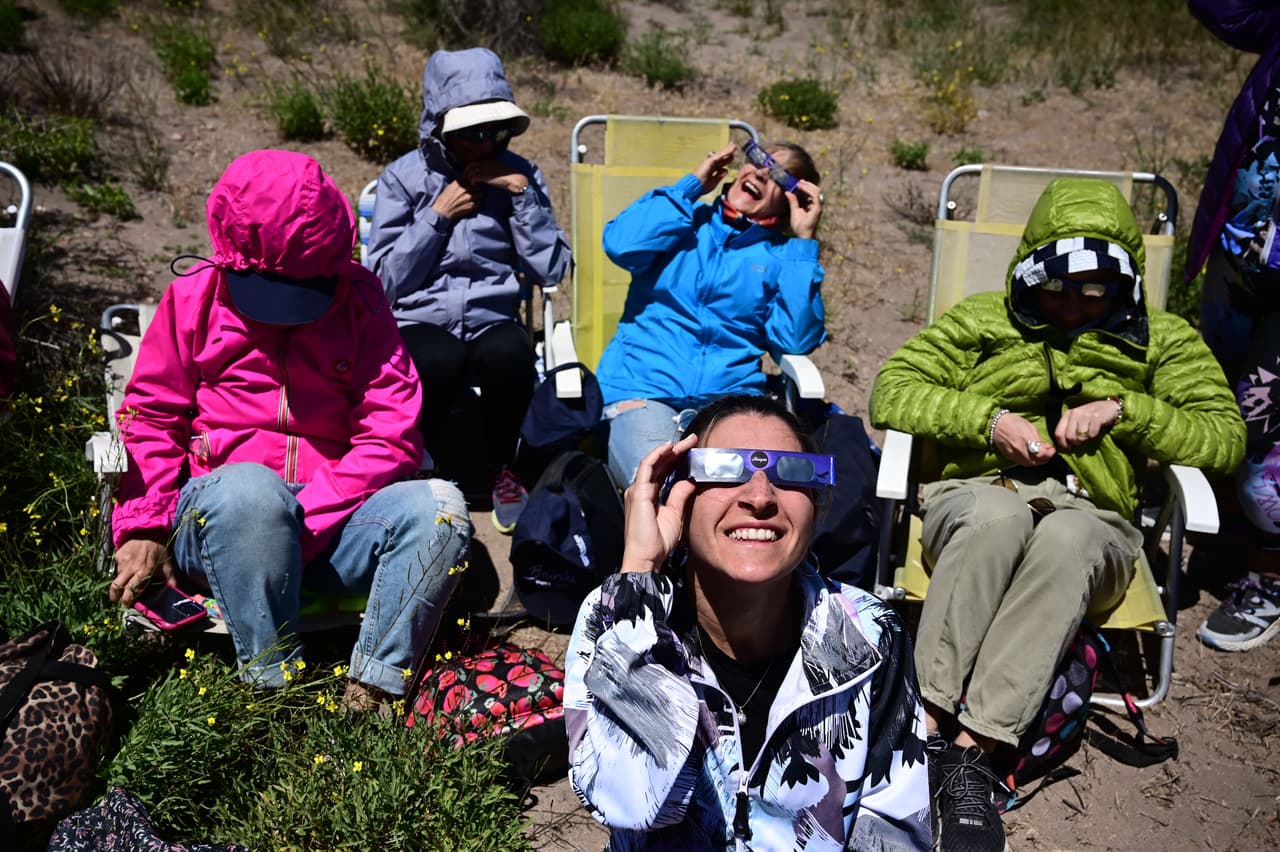 La gente observa el eclipse en Piedra del Águila, provincia de Neuquén, Argentina. El subsecretario de Turismo local, Germán Bakker, se mostró esperanzado de recibir turistas para que pudieran disfrutar el fenómeno "siempre tomando los recaudos necesarios de seguridad sanitaria".