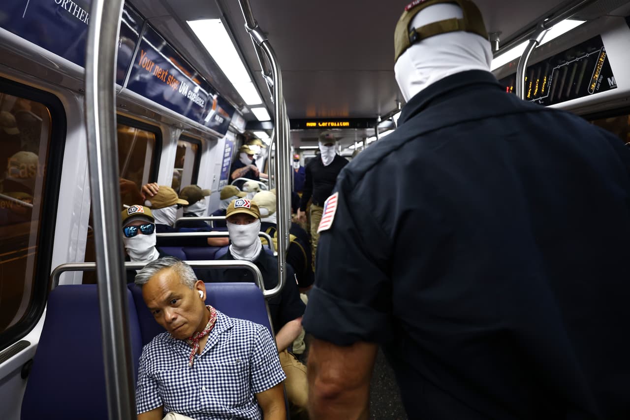 Roswell Encina evita el contacto visual con los miembros del grupo supremacista blanco Patriot Front mientras viaja en el metro de Washington el 4 de Julio. (Foto de Finn Gomez/Getty Images)