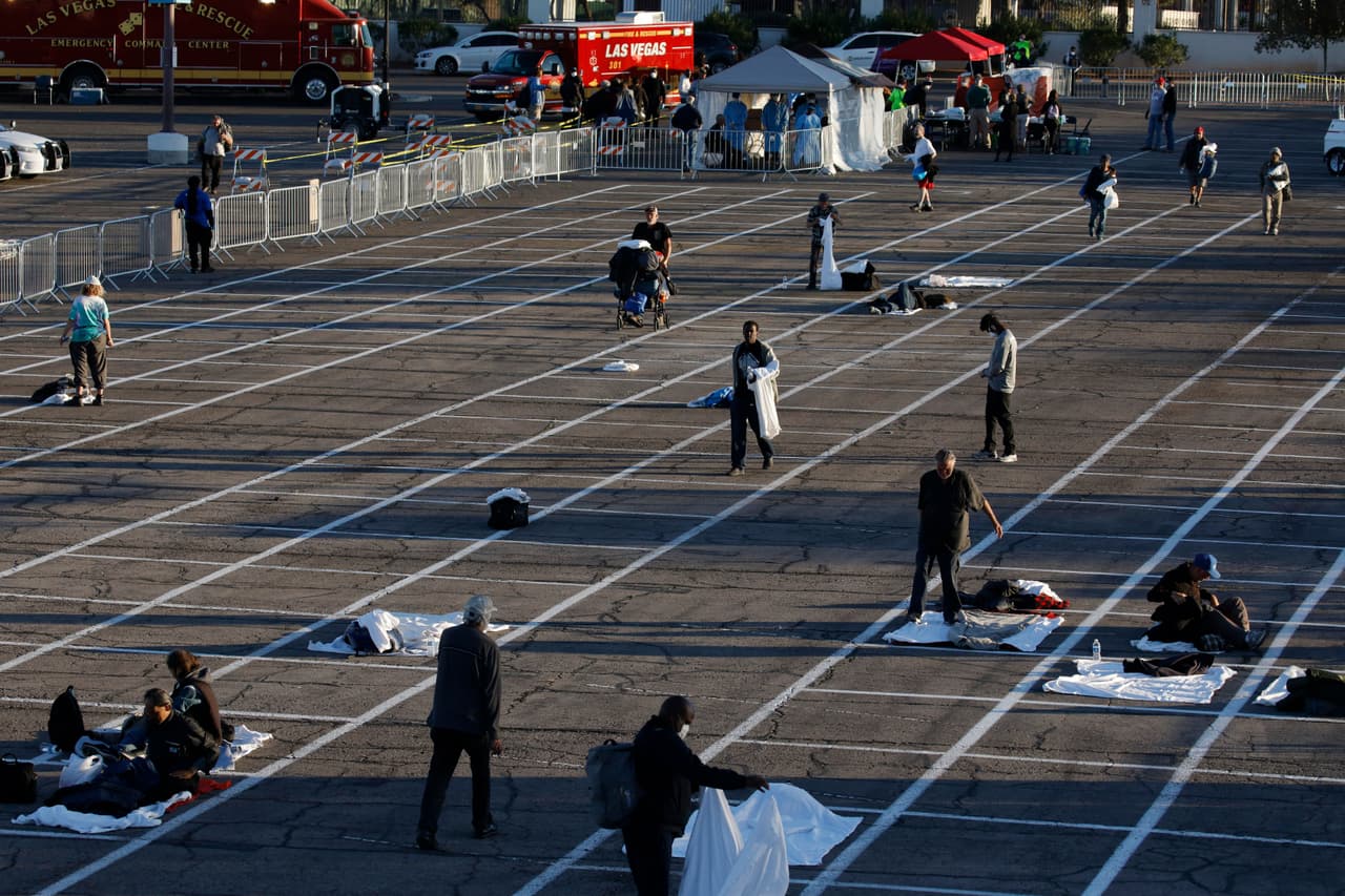 La gente se prepara para dormir en áreas marcadas con cajas pintadas en el suelo de un estacionamiento en un campamento improvisado para personas sin hogar el lunes 30 de marzo de 2020 en Las Vegas.