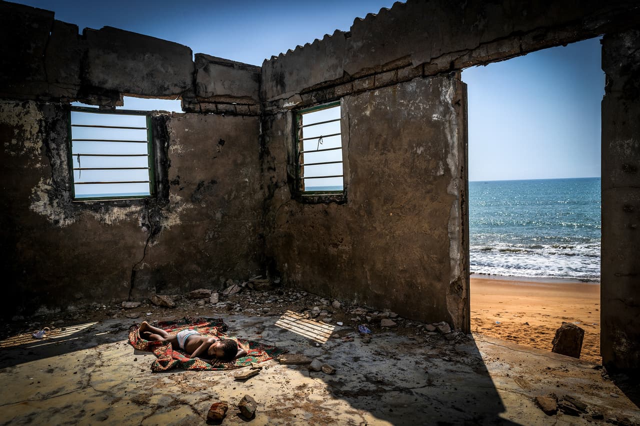 <b>‘Los hijos de la marea creciente’ </b>
<br>
<br>Un niño duerme dentro de su casa destruida por la erosión costera en Togo, África Occidental, una imagen que hizo merecer a su autor la máxima distinción del concurso Fotógrafo ambiental del 2021. Desde hace 14 años este galardón reconoce a los fotógrafos comprometidos con el medio ambiente y el desarrollo de la humanidad de manera sostenible.
<br>
<br>“Los niveles del mar en más de 5,000 millas de la costa en 13 países de África Occidental continúan aumentando y tragándose todo a su paso”, explicó la organización del concurso en un comunicado. “Miles de personas se han visto obligadas a abandonar sus hogares para evitar una muerte segura'', agregó.
<br>