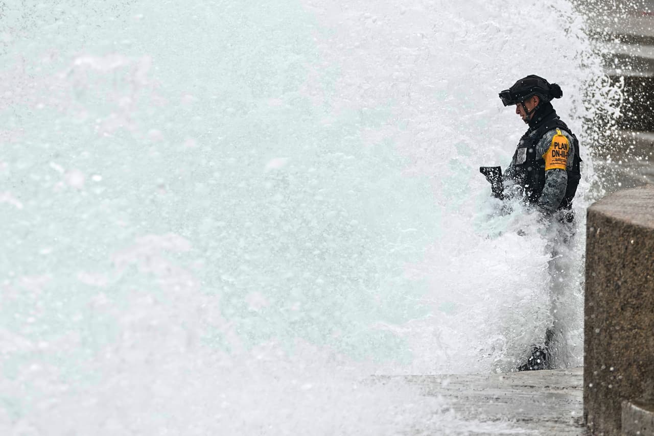Un miembro de la Guardia Nacional permanece de pie entre las salpicaduras de agua mientras una ola golpea el malecón provocado por el huracán Simón, en Puerto Vallarta, México, el domingo 11 de octubre de 2026.