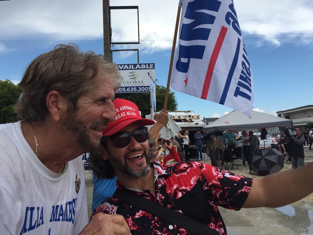 “Estamos apoyando la idea del proyecto del presidente Donald Trump. Está buscando la forma de fortalecer las acciones en contra del régimen de los militares castristas que tienen el control de la república de Cuba y que los turistas americanos que vienen a Cuba tengan dificultades con las restricciones”, defendía Miguel Saavedra (a la izquierda de la imagen). El dirigente de la Vigilia Mambisa, uno de los grupos más conocidos del núcleo duro del exilio, desde hace décadas no se pierde una sola manifestación en contra del gobierno castrista en Miami. En la foto posa con otro partidario del presidente que llegó hace 18 años a EEUU en balsa.