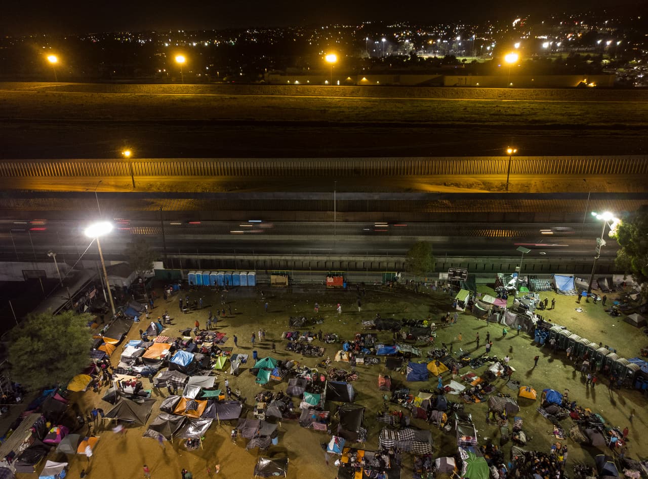 Una vista aérea del refugio en la Unidad Deportiva Benito Juárez en la frontera norte de Tijuana, al fondo el territorio de Estados Unidos.