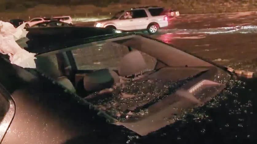 En esta imagen tomada de un video, el granizo rompe la ventana de un vehículo durante una tormenta en el anfiteatro Red Rocks, el miércoles 21 de junio de 2023 por la noche, en Morrison, Colorado.