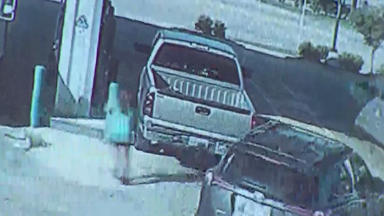 Mientras en hombre arranca la camioneta, la mujer desesperada intenta detenerlo.