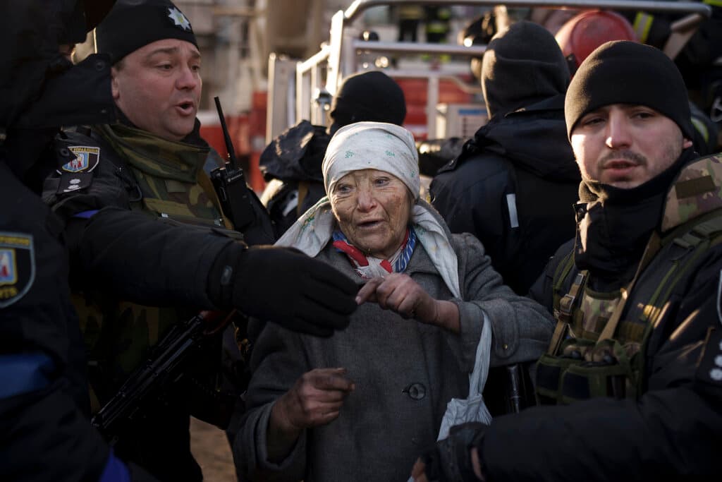 Una señora evacuada por policías en un edificio atacado por artillería rusa la mañana de este martes en Kiev.