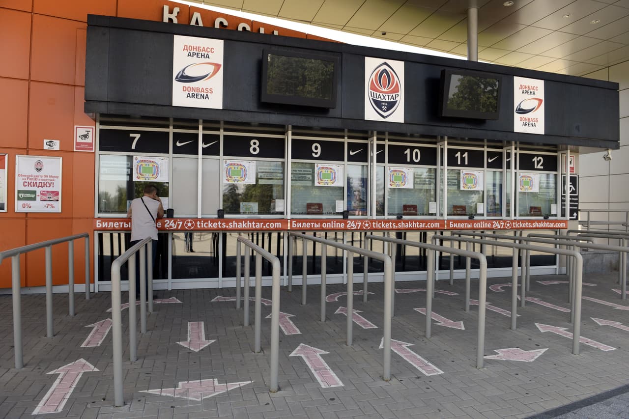 TO GO WITH AFP STORY BY MARION THIBAUT A man stands at the ticket office of the Donbass Arena football stadium in Donetsk on July 27, 2014. Football club Shakhtar on July 27 kicks off the season far from its native Donetsk in eastern Ukraine, where fighting is raging between government forces and pro-Russian rebels. For its first match, the title holder should be playing at home in the 50,000-seater Donbass Arena built for the Euro 2012 championships. AFP PHOTO / ALEXANDER KHUDOTEPLY (Photo credit should read Alexander KHUDOTEPLY/AFP/Getty Images)