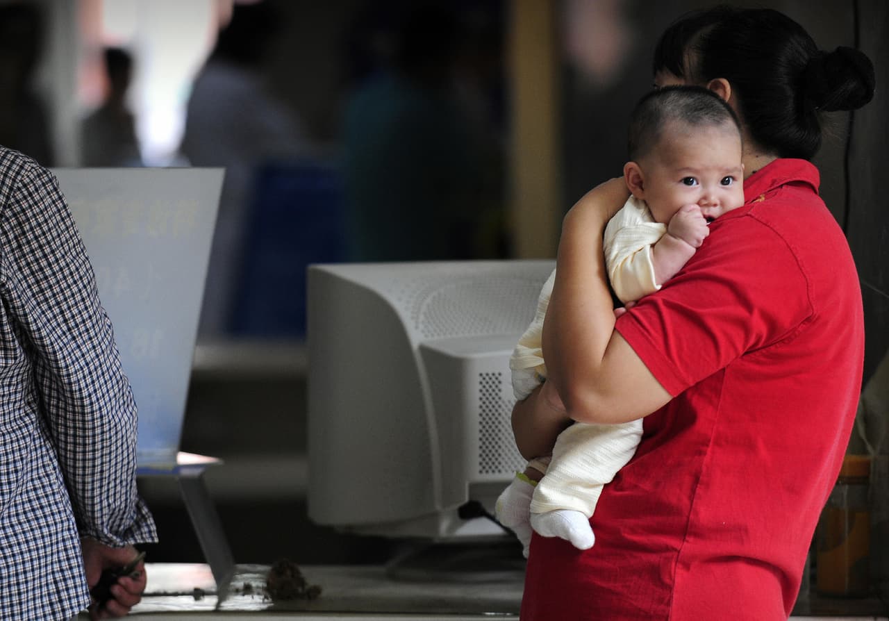 A mother holds her baby at a children's hospital in Beijing on September 23, 2008 as China's toxic milk scandal escalated after officials admitted nearly 53,000 children had been sickened by contaminated products. The Chinese company Sanlu Group, whose tainted baby milk triggered the food safety scare, failed to report complaints about the product for months, state media said. AFP PHOTO/Peter PARKS (Photo credit should read PETER PARKS/AFP/Getty Images)
