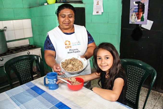 Una niña recibe comida en Guatemala.