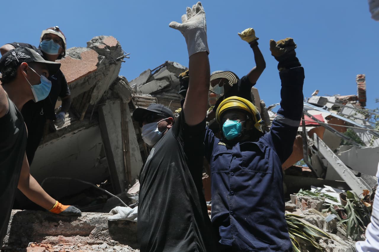 La gente pide silencio durante la búsqueda de supervivientes tras el terremoto que sacudió Cali, Colombia, el lunes 10 de agosto de 2026.