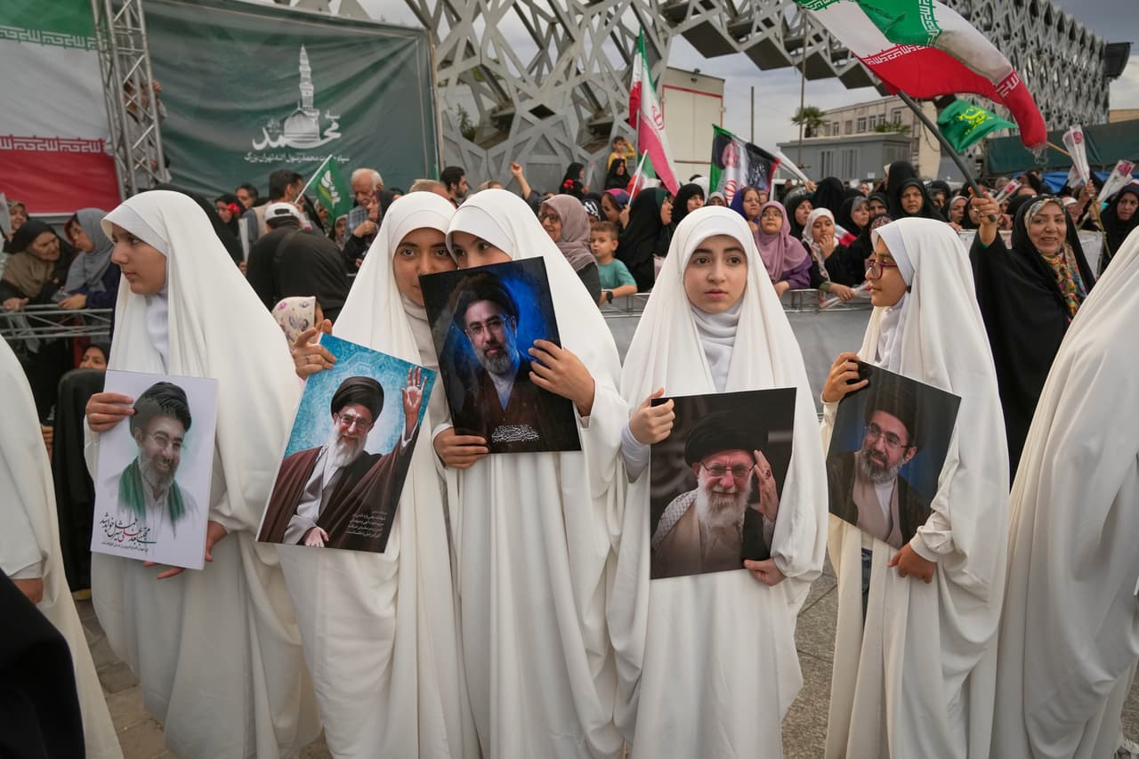 Niñas sostienen retratos del líder supremo de Irán, el ayatolá Mojtaba Khamenei, y de su difunto padre, el también exlíder supremo, el ayatolá Ali Khamenei, mientras observan una ceremonia de boda colectiva para parejas que participan en la campaña progubernamental "Janfada" o "Sacrificio por Irán" en Teherán, Irán