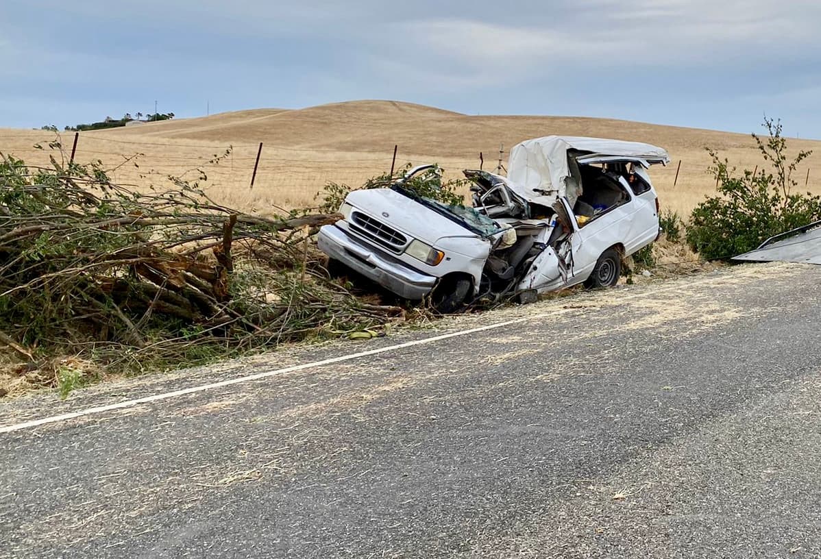 La van de color blanco en la que quedaron atrapados varios trabajadores agrícolas tras el accidente.