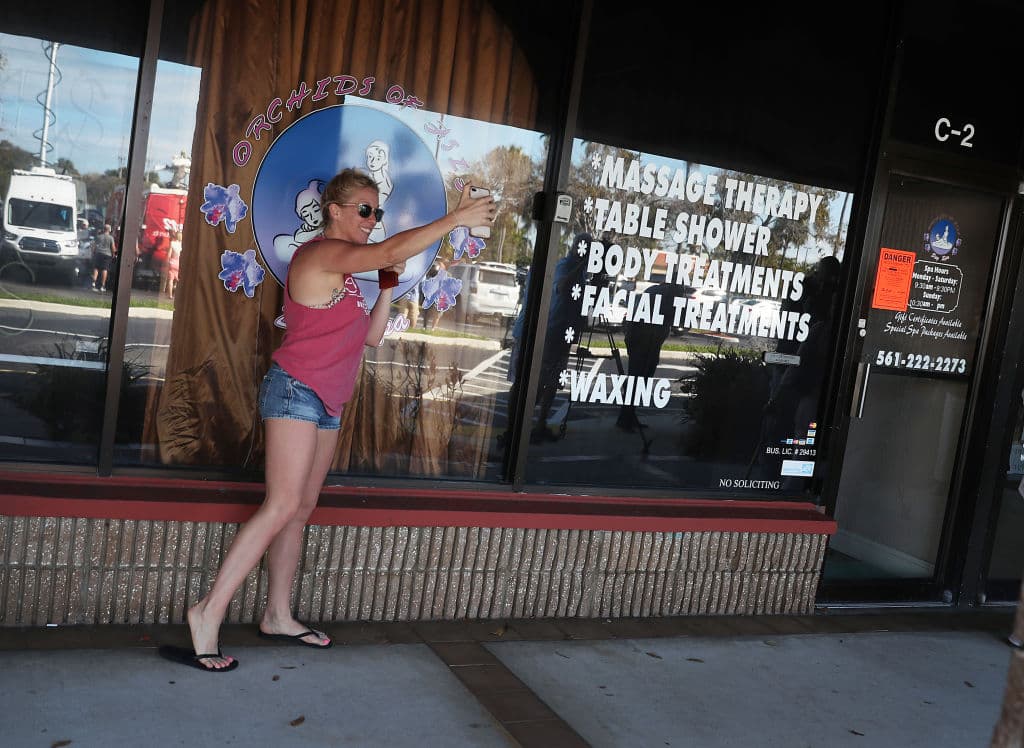 Otra espontánea se toma una selfie frente al lugar donde supuestamente Robert Kraft solicitó servicios de prostitución.
