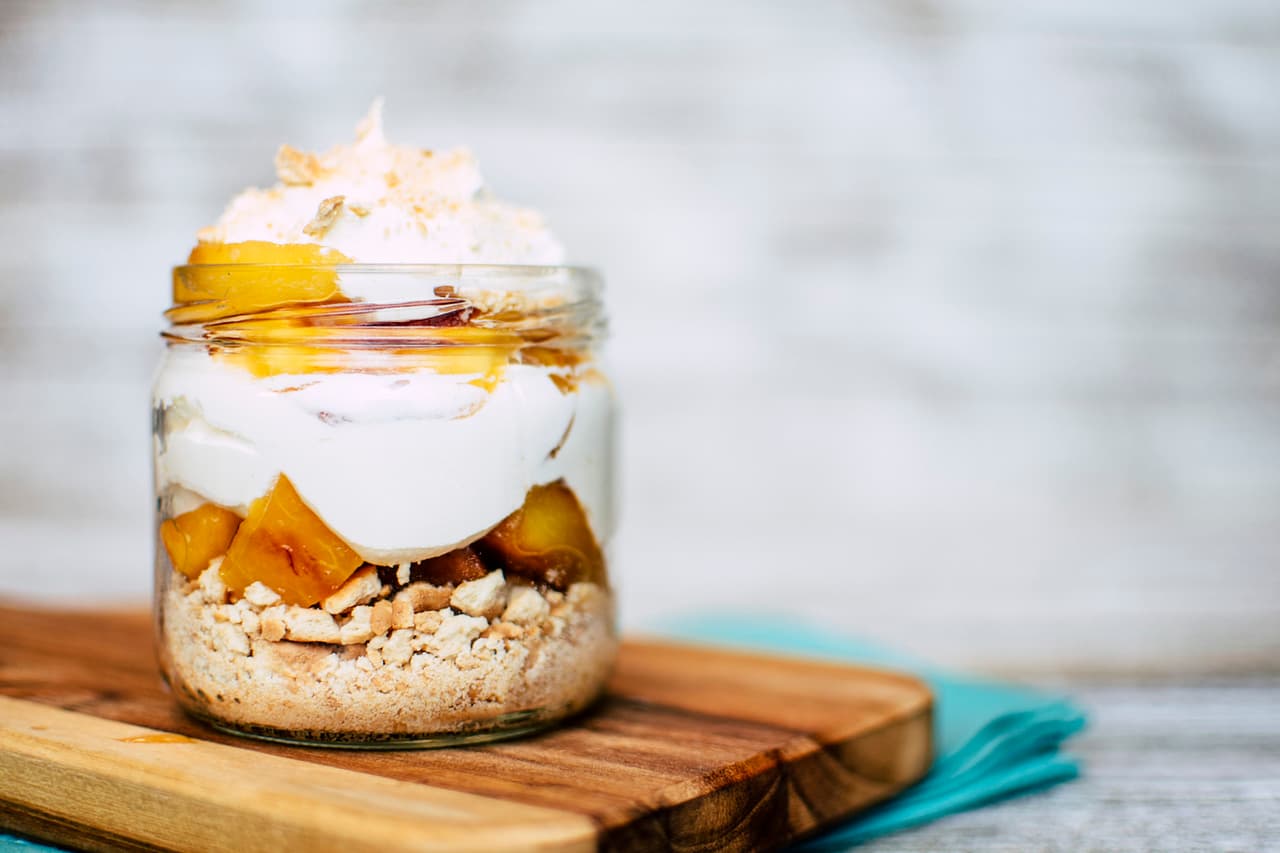 Duraznos con crema y polvo de galletas