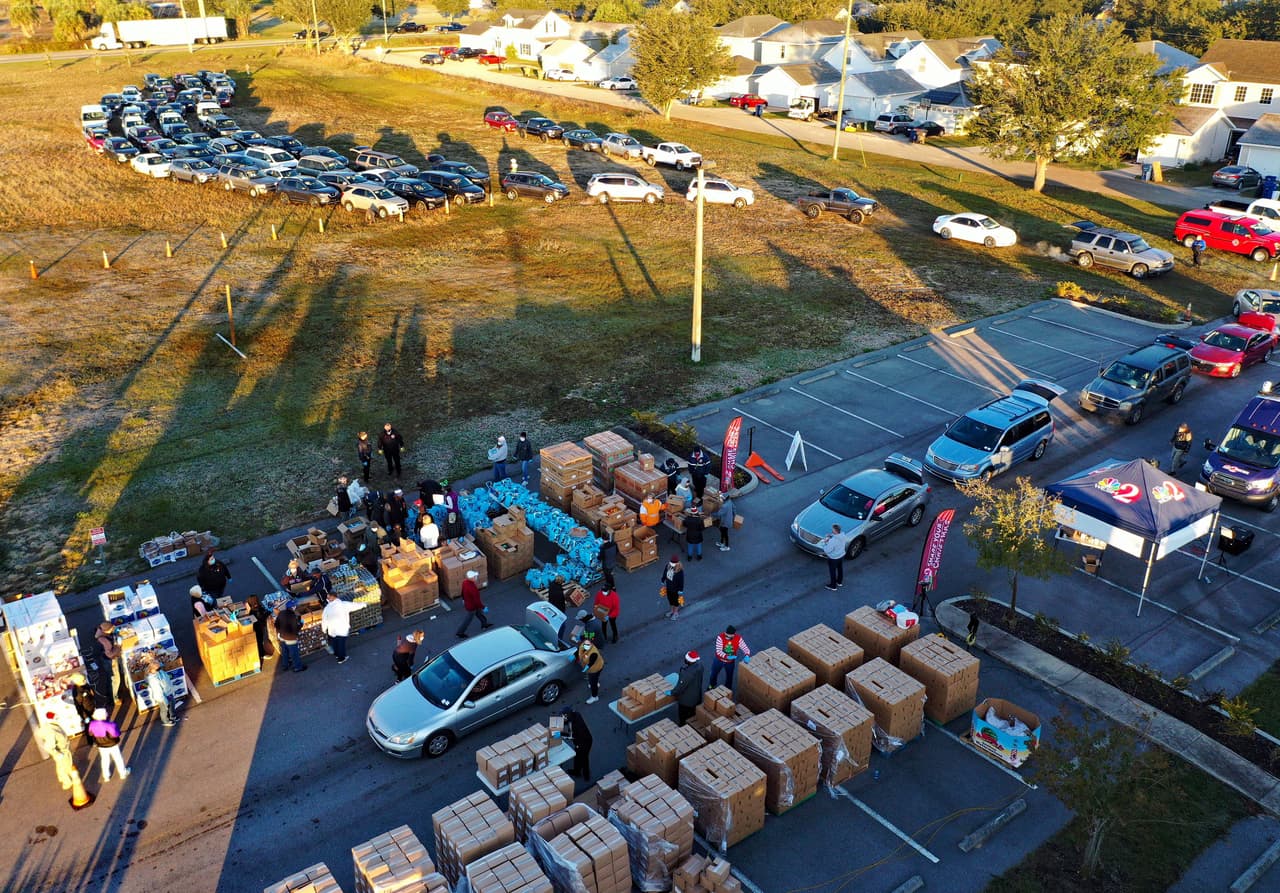 <b>Filas para recibir comida en navidad. </b>Voluntarios cargan con cajas de alimentos los autos de los asistentes a un evento de donaciones de comida en en Groveland, Florida. Los bancos de alimentos de Estados Unidos luchan por atender a quienes enfrentan inseguridad alimentaria durante la inédita temporada navideña en medio de la pandemia de covid-19. 9 de diciembre.
<br>