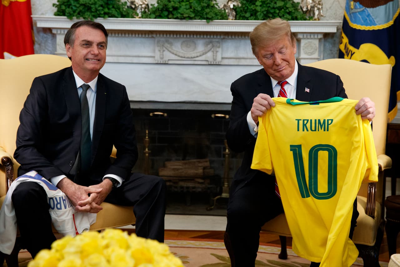Jair Bolsonaro entrega a Donald Trump una camiseta de la selección nacional de fútbol de Brasil en el Despacho Oval, el martes 19 de marzo de 2019. (Foto de AP/Evan Vucci)