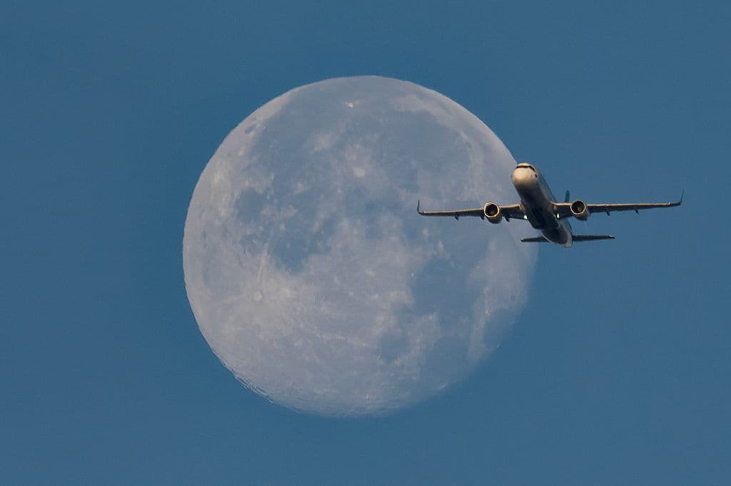 La luna menguante se ve detrás de un avión de pasajeros que desciende sobre Viena, Austria, en la madrugada del 7 de noviembre de 2025.
