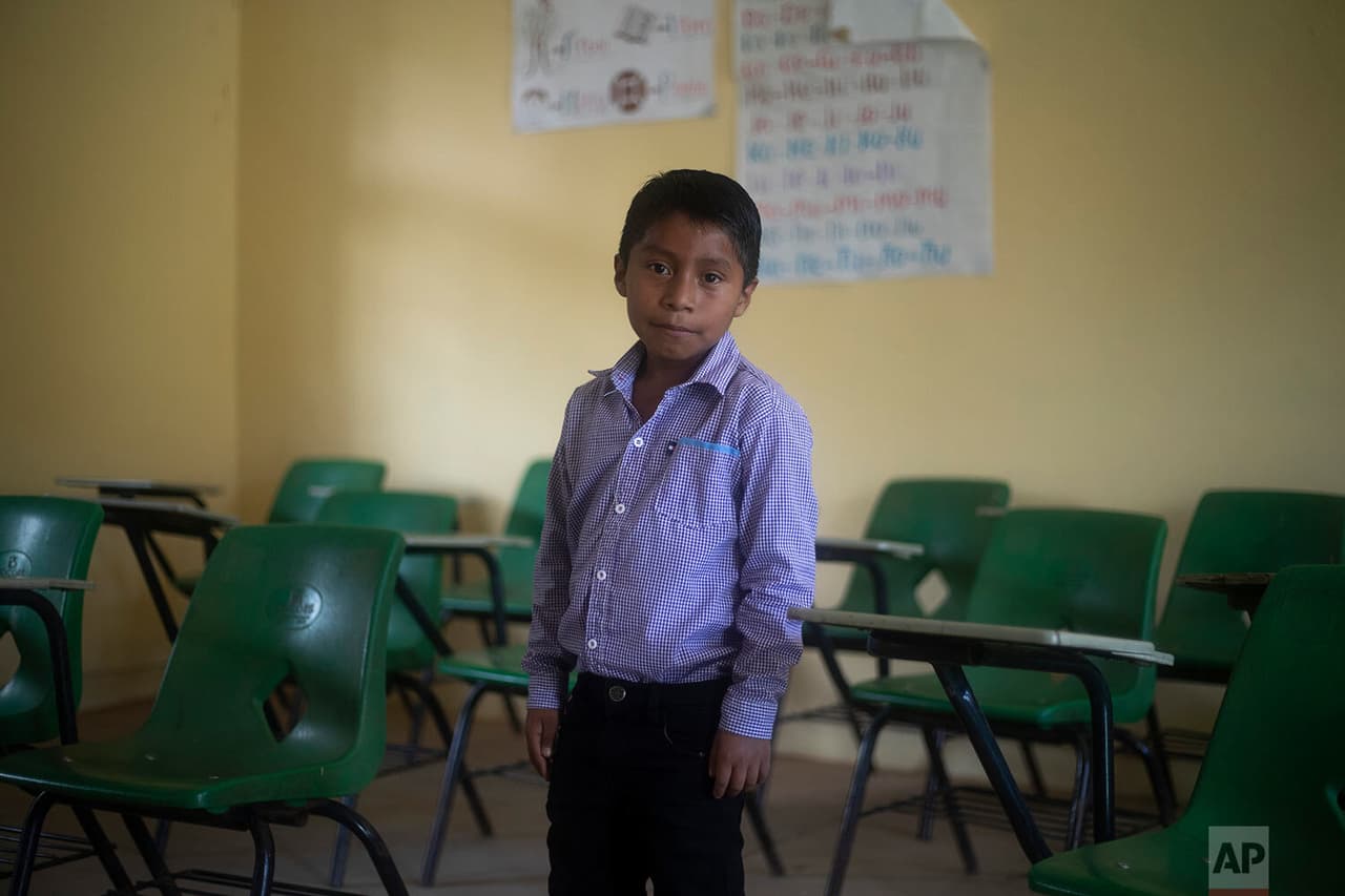 Héctor Vásquez posa para un retrato dentro de su antiguo salón de clases en la escuela Nuevo Yibeljoj.
<b>Vásquez es uno de los 12 hermanos que trabajan en los campos de café todos los días</b> en lugar de solo los fines de semana, mientras su padre los ayuda con las tareas escolares que les dejan los maestros.