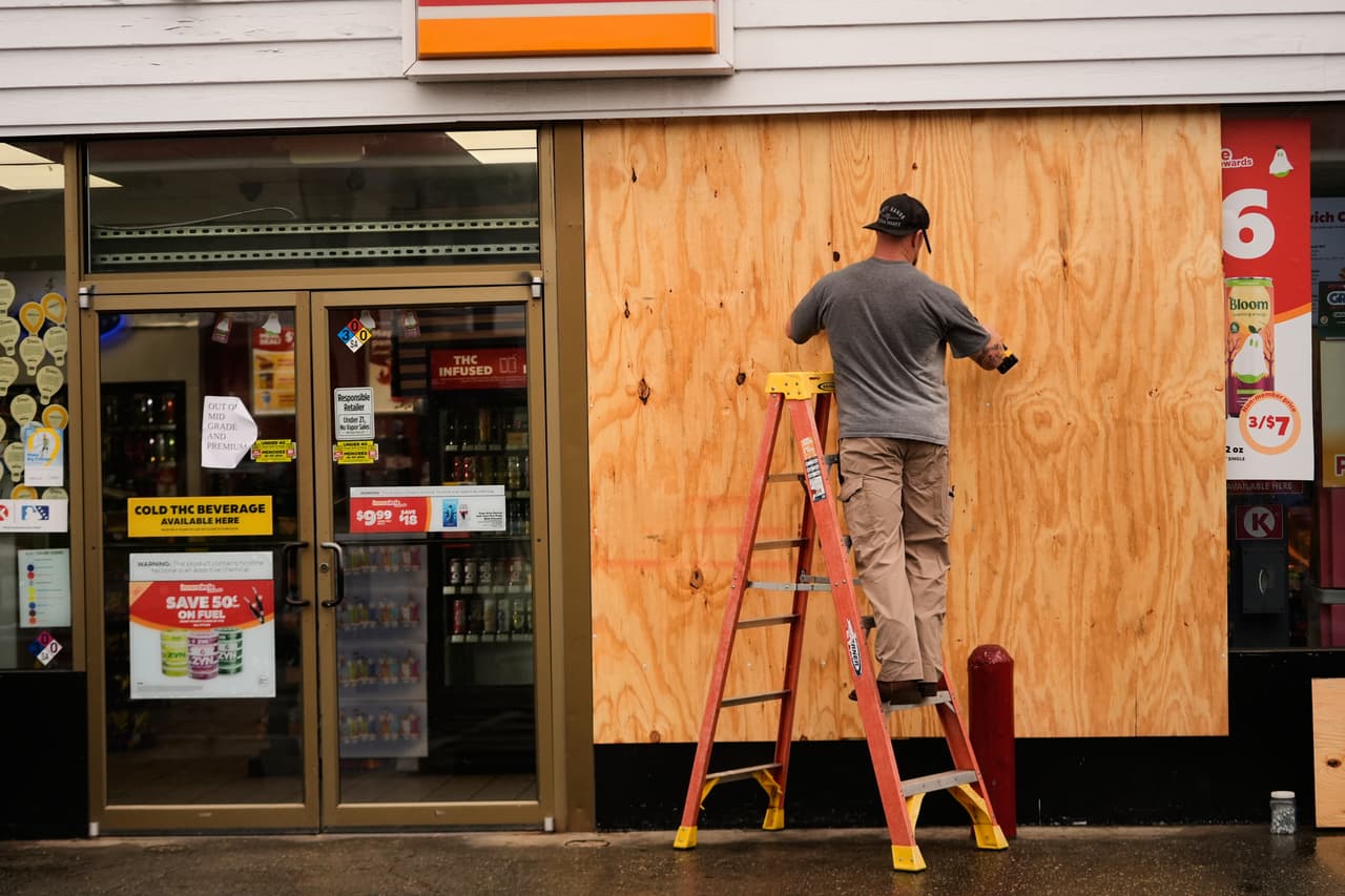 Jason Coffey tapia una tienda de conveniencia en una gasolinera mientras el huracán Isaias se acerca a Pensacola Beach, Florida, el viernes 9 de octubre de 2026. (Foto AP/Gerald Herbert)