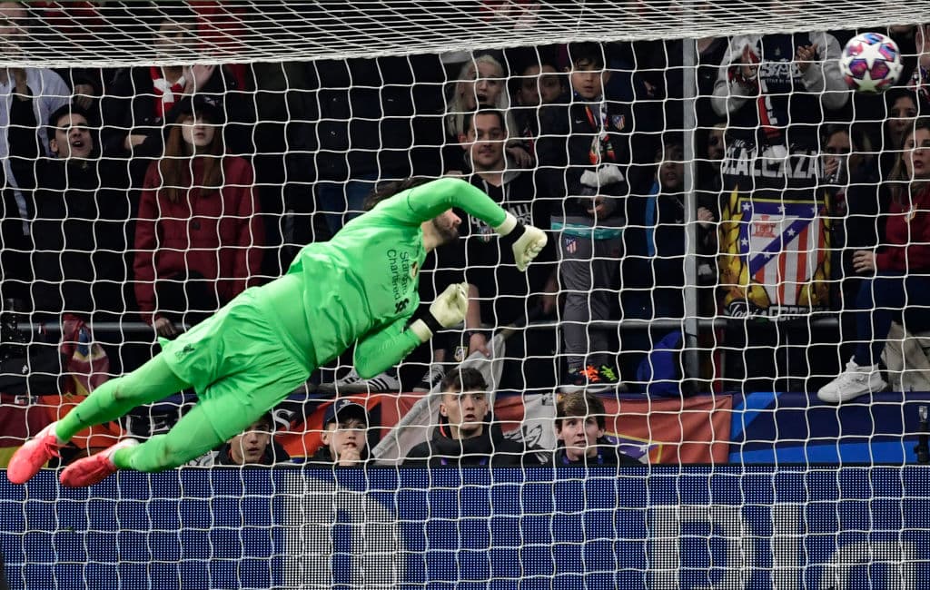 Alisson se estira cuan largo es por un remate, pero el balón se va por encima de su portería sin que llegue a la red.