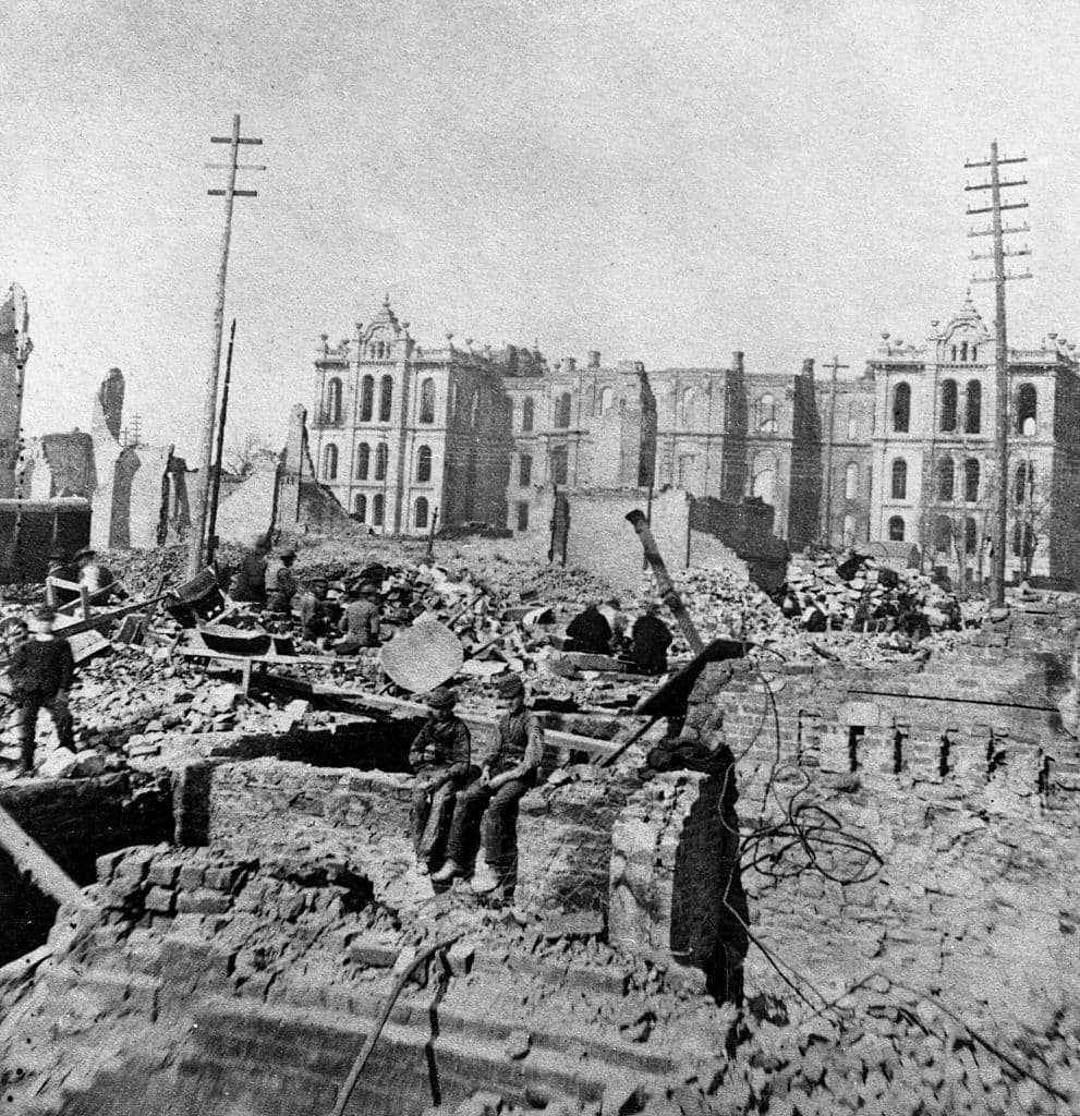 Two boys sit on top of a partial stone wall in the wreckage of a burned-out building at Madison and Clark Streets, with the Court House in the background following the great Chicago fire of October 8 - 10, 1871, Chicago, Illinois. (Photo by Hulton|Archive/Getty Images)