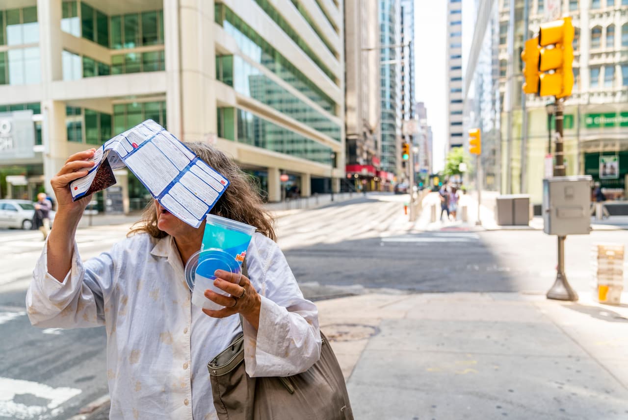 Con el inclemente sol, esta mujer busca taparse improvisadamente.