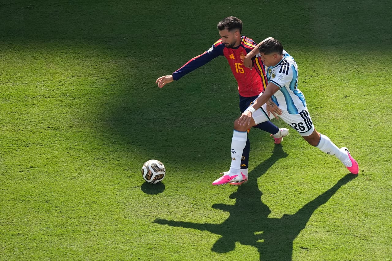 Alex Baena y Nahuel Molina luchan por el balón.