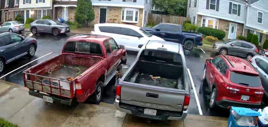 Agente busca debajo de vehículos estacionados en Herdon.