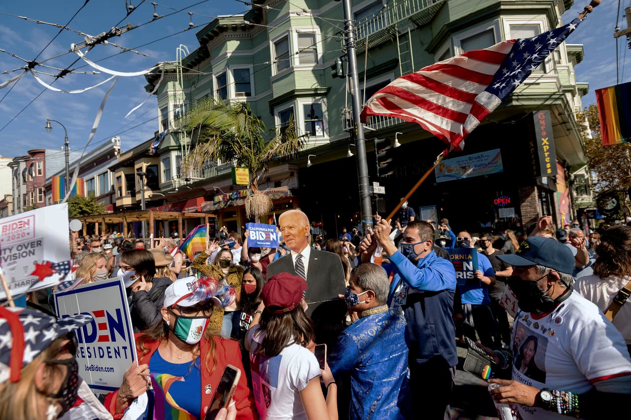 La gente lleva una figura a escala del presidente electo Joe Biden mientras celebra su victoria en el distrito de Castro de San Francisco este sábado 7 de noviembre, tras el anuncio del conteo de votos que le dieron una ventaja irrefutable sobre Donald Trump.