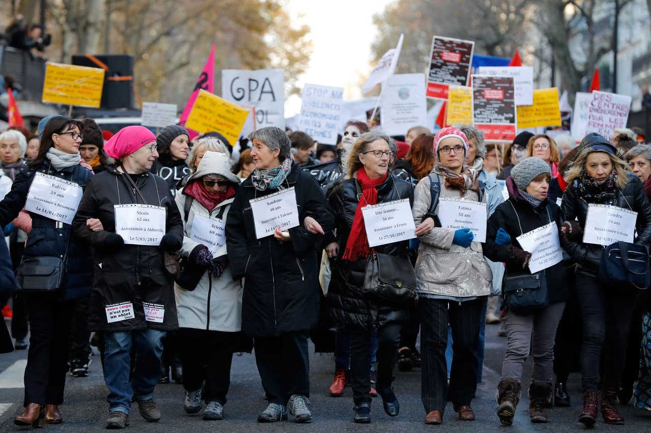 Las mujeres sostienen carteles con los nombres y edades de mujeres que fueron víctimas de violencia doméstica durante una manifestación en París.