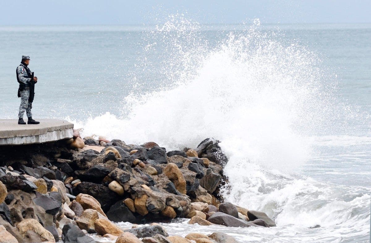 Otro miembro de la Guardia Nacional de México permanece de pie en el malecón de Puerto Vallarta mientras las olas rompen contra la costa ante el posible impacto del huracán Simón en Puerto Vallarta, estado de Jalisco, México, el 11 de octubre de 2026.