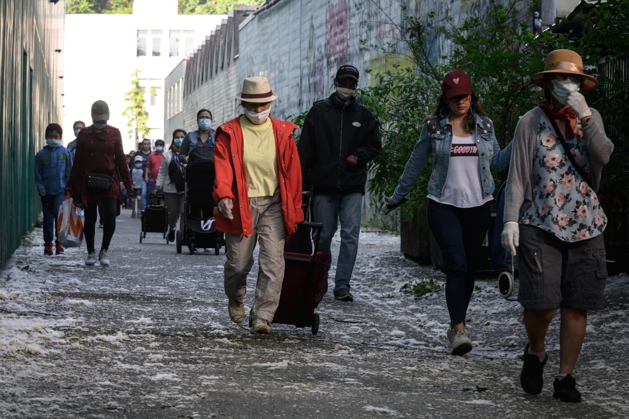 Larga fila de personas en Ginebra a la espera de recibir una bolsa de alimentos gratis.
