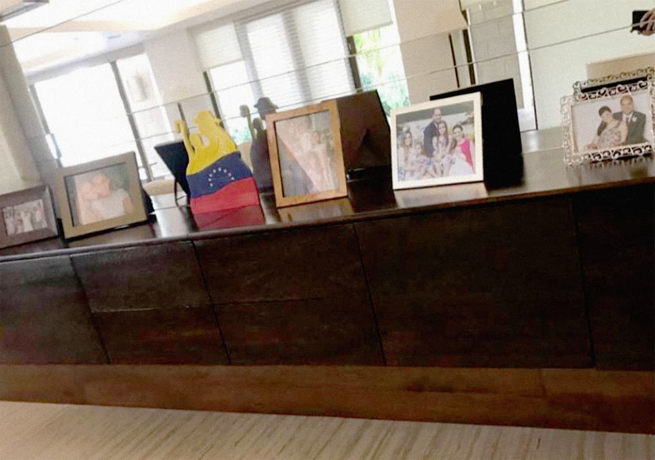 Fotos familiares y una escultura con la bandera de Venezuela dentro de la casa.