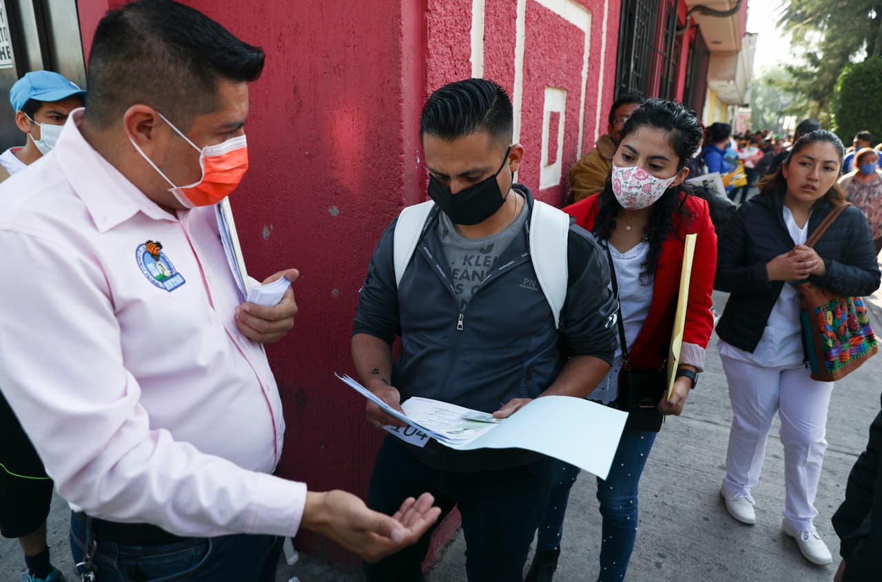 Un trabajador revisa la documentación de las personas que buscan aplicar a un puesto en el sector público de salud en Ciudad de México.